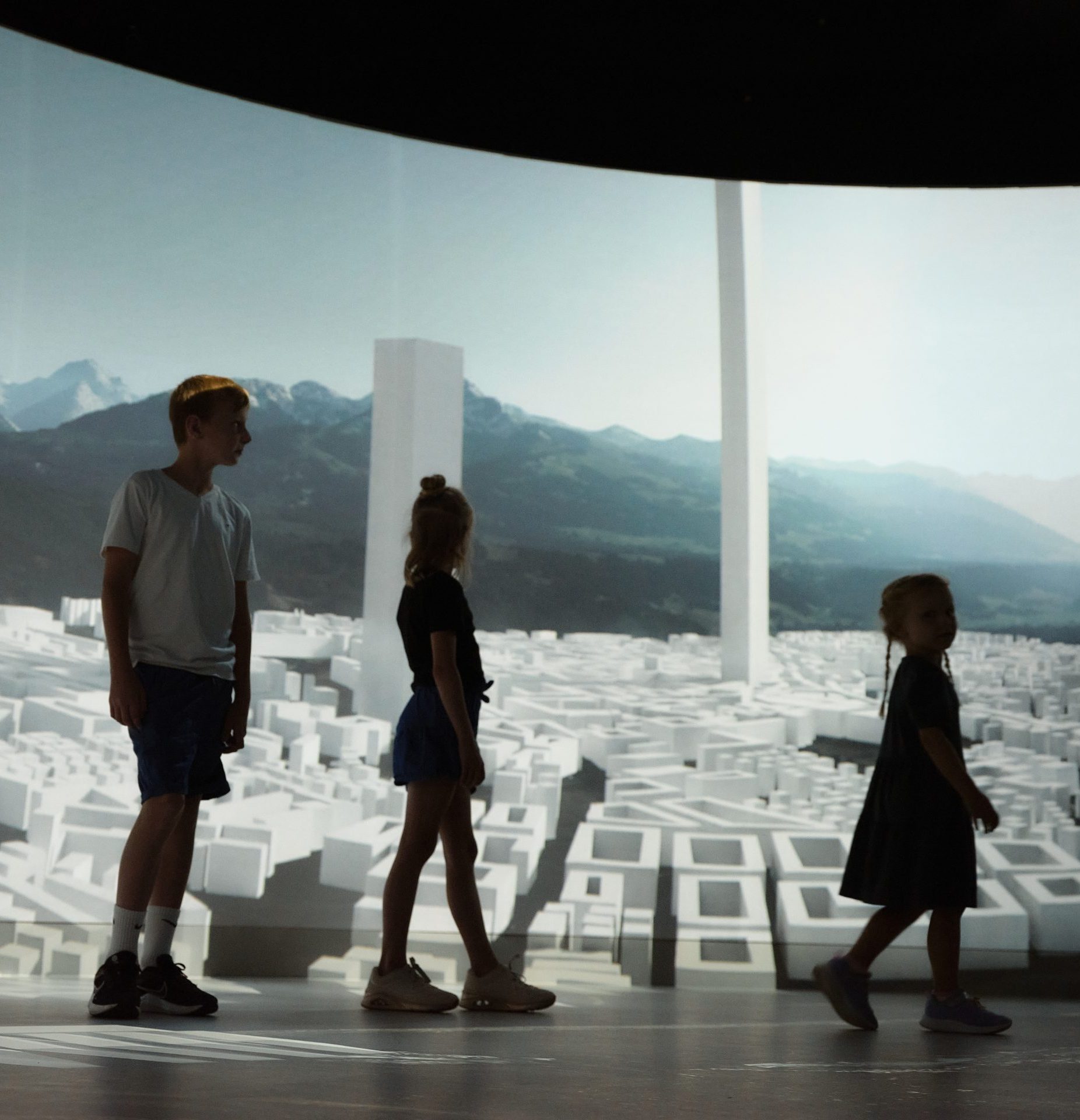 Kinder stehen staunend im 360-Grad-Projektionsraum von EXPERIENCE TIROL in Innsbruck